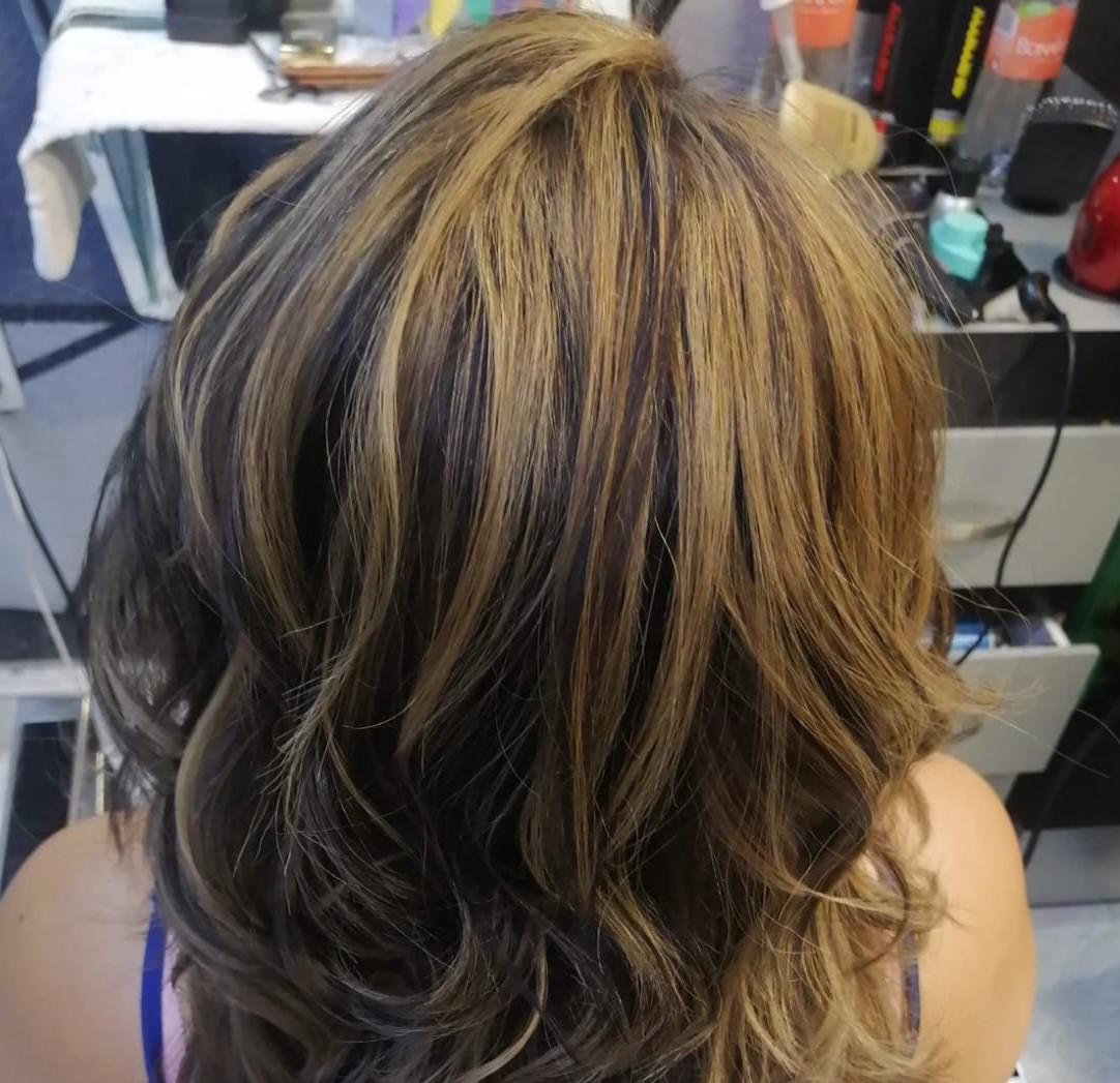 Professional hair dyeing process showing hair color application with professional tools and color mixing in a modern salon